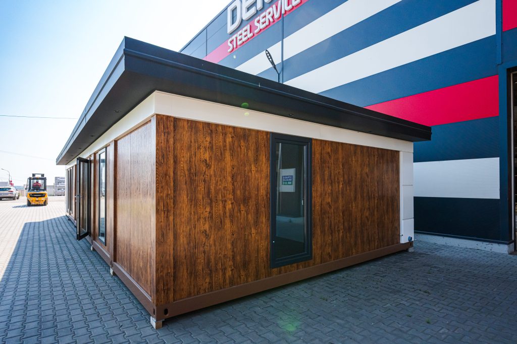 Construcție modulară cu placare imitație lemn în curtea fabricii DEMCAR